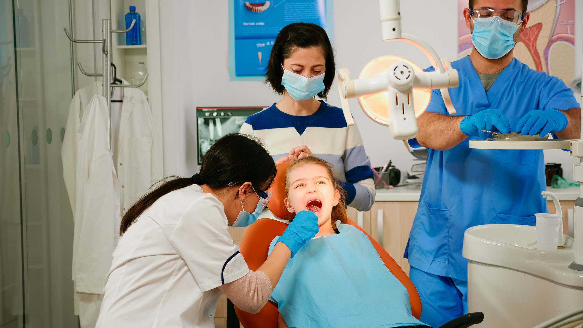 Dentistry doctor speaking to kid sitting on stomatological chair