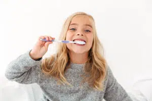 A kid with a toothbrush demonstrating good dental habits as part of a pediatric dentist toothbrush recommendation in Beverly Hills.