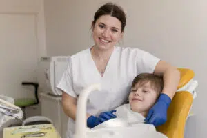 A female pediatric dentist with a warm and friendly expression demonstrating key qualities of an excellent pediatric dentist