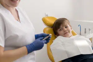 A smiling child during early dental visits for children.