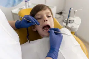 A dentist performing an examination on a child, a step in determining the need for procedures such as Pulpotomy vs. Pulpectomy in Beverly Hills