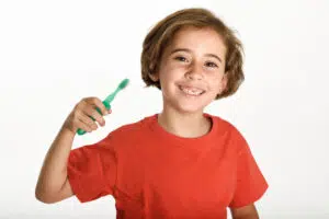 Child holding a toothbrush, representing essential kids dental health tips and a positive brushing routine in Beverly Hills