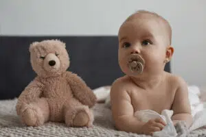 A baby with a pacifier , illustrating Pacifiers and Baby Teeth Development Beverly Hills.