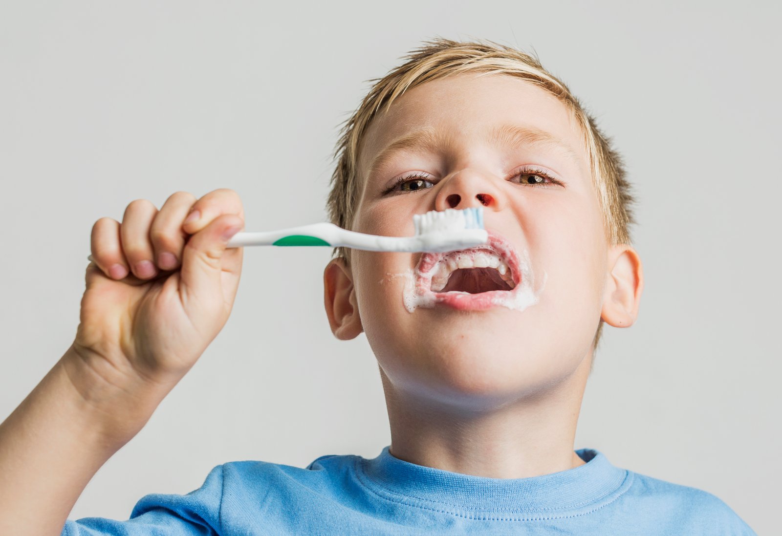 A child brushes their teeth with a toothbrush, relevant to Fluoride & Baby Toothbrushes in Beverly Hills.