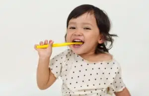 A toddler brushes their to prevent Baby Bottle Tooth Decay in Beverly Hills.