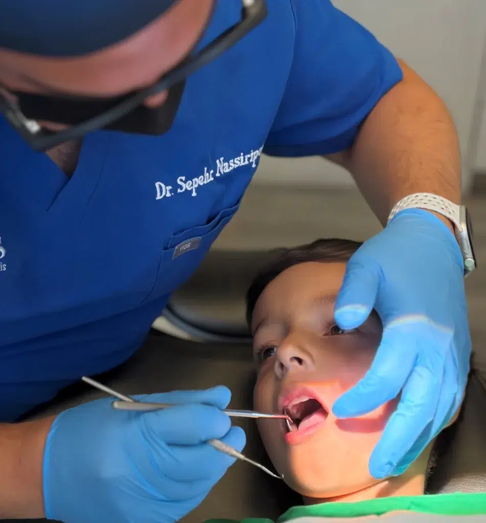 Pediatric Orthodontist in Beverly Hills Dr. Nasiripour examining a child's teeth for orthodontics